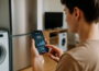 Person misst den Stromverbrauch im Haushalt mit Smartphone-App