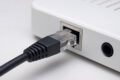 Netzwerkkabel mit RJ45-Stecker wird in einen Router eingesteckt